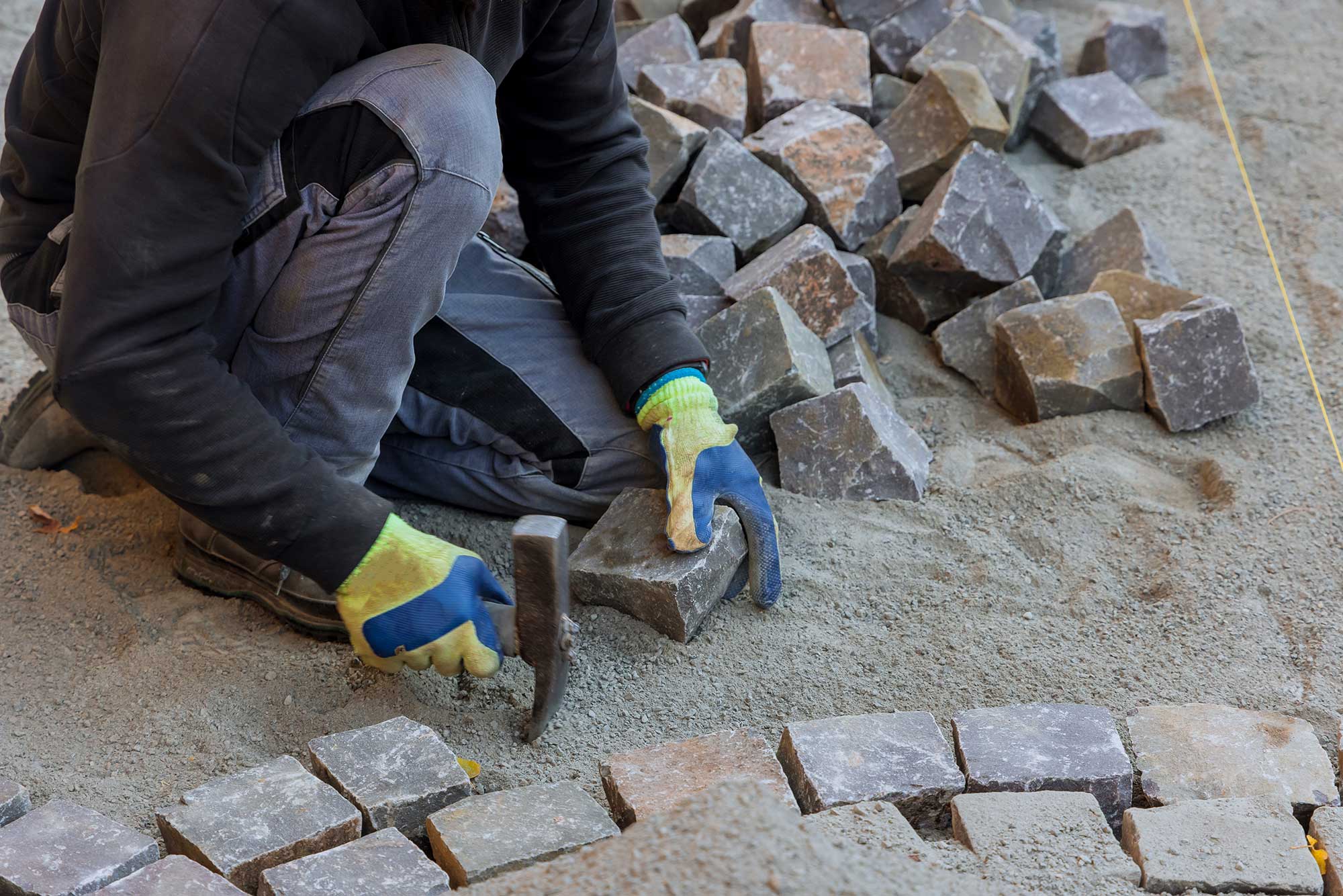 road-master-in-gloves-lays-paving-stones-in-layers