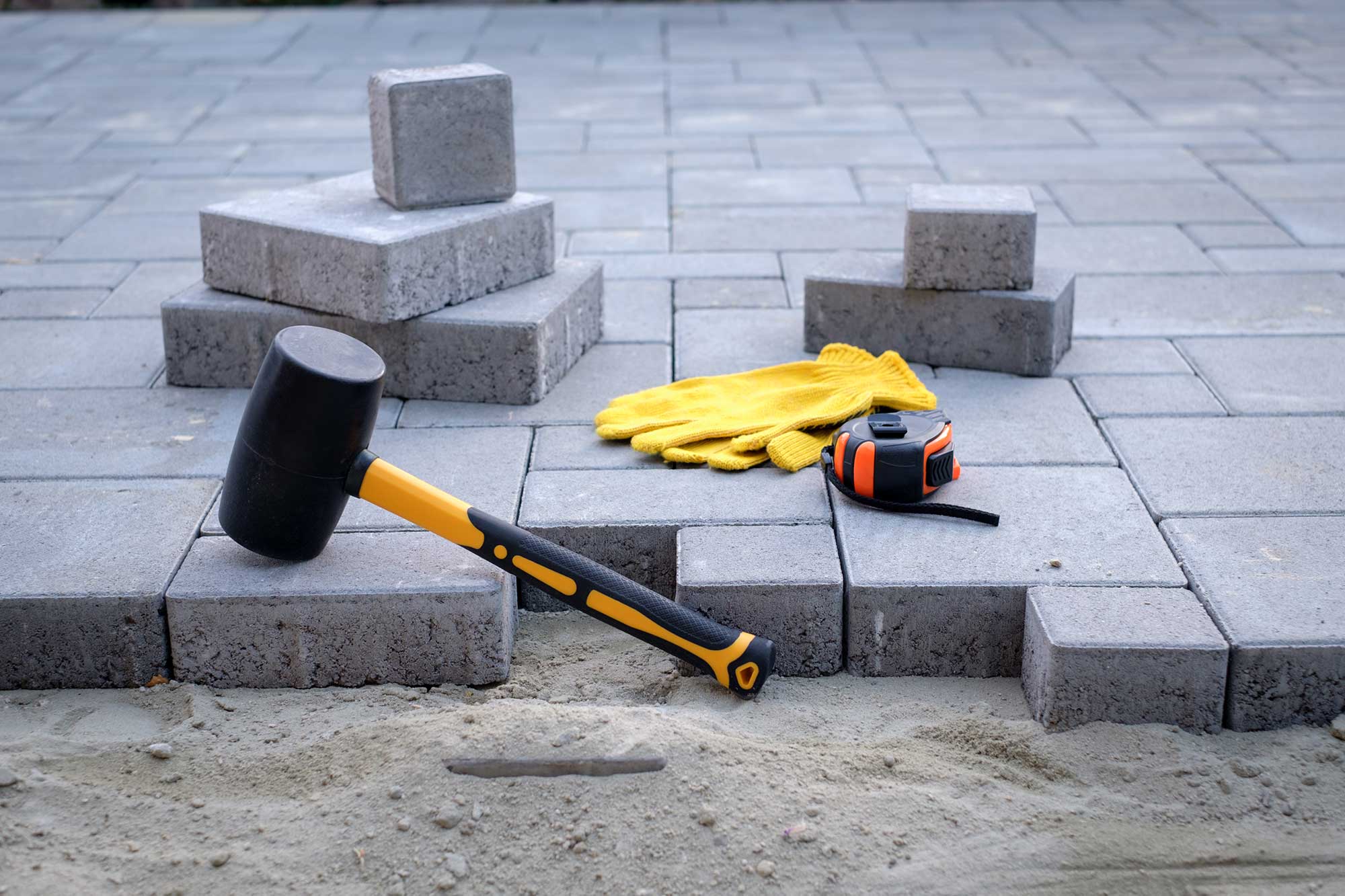 the-master-in-yellow-gloves-lays-paving-stones