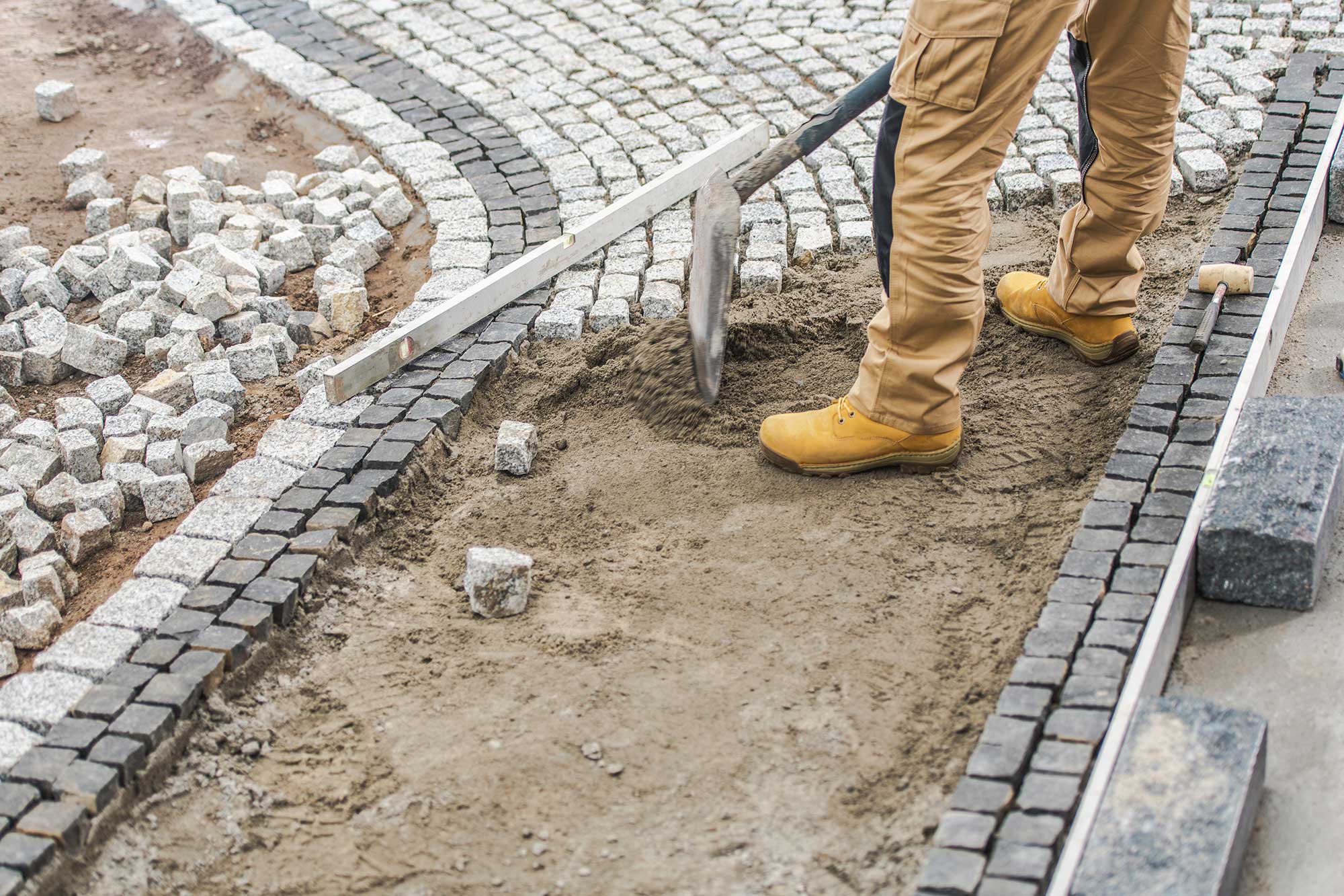 worker-paving-residential-path-using-granite-brick